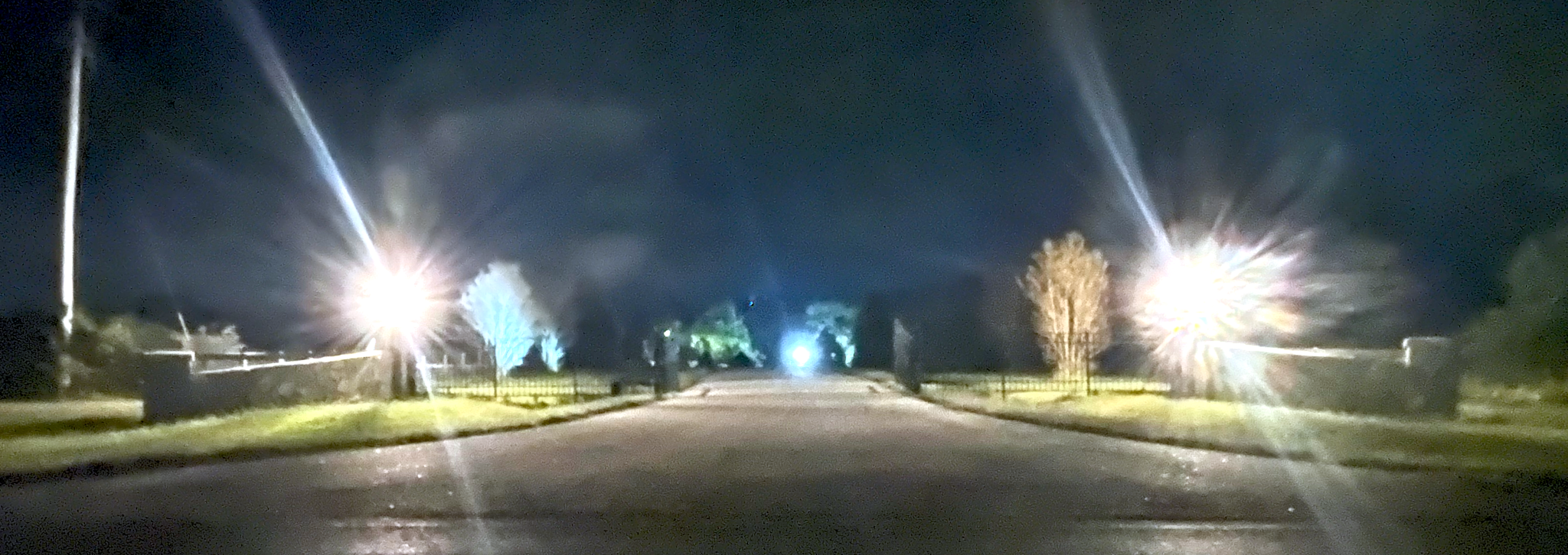 A front stone gate with lights on either side